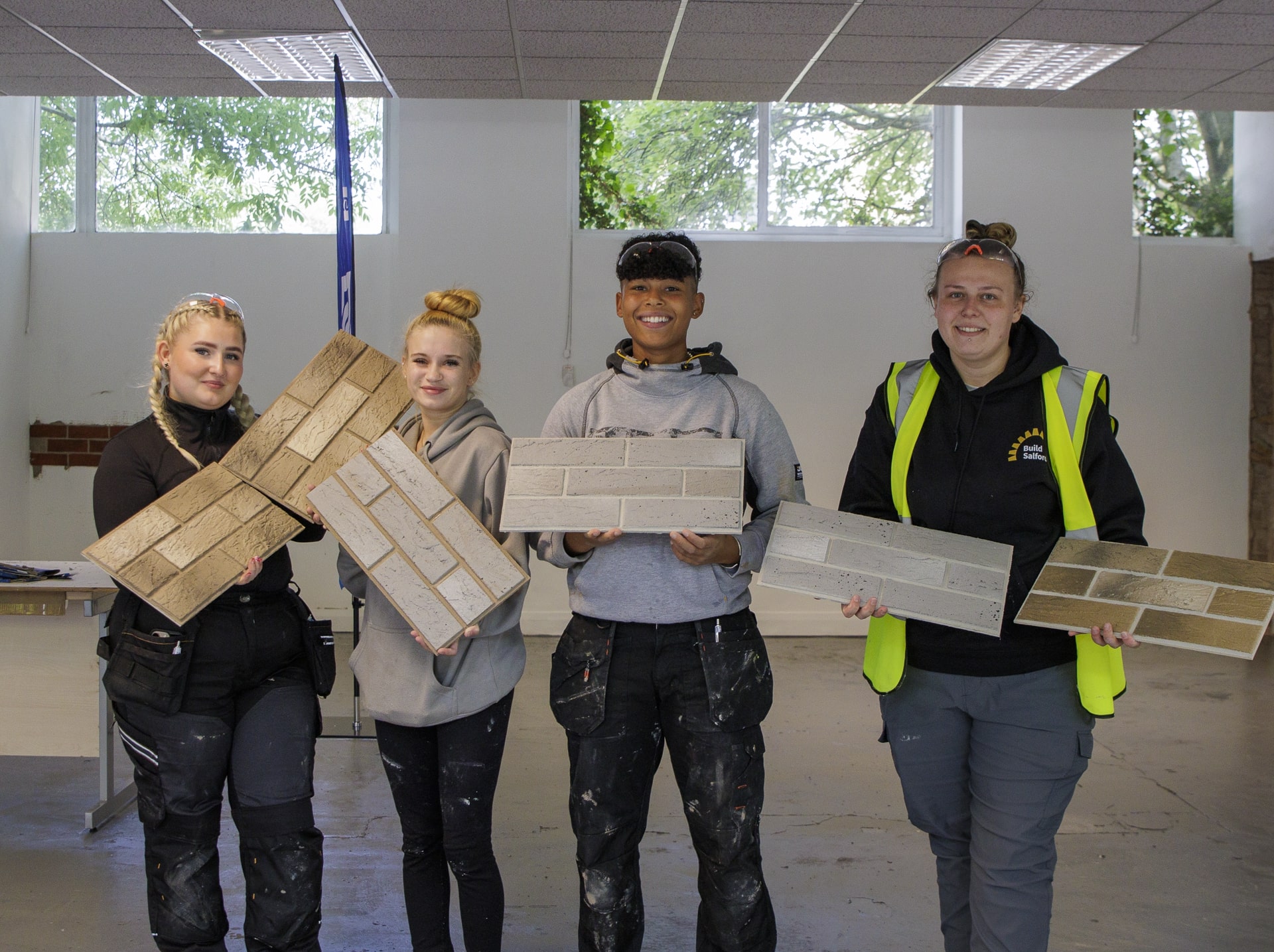Three women stand posing with brickslip samples