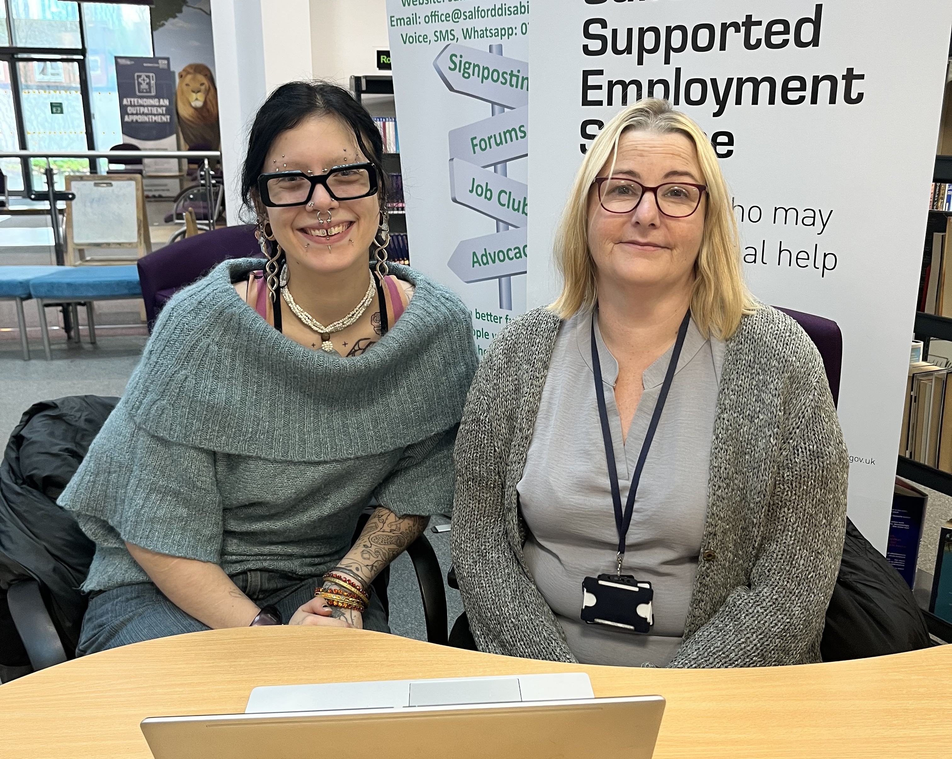 Two women sat next to each other at a desk