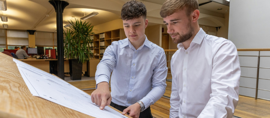 Two young men looking at plans in an office envrionment