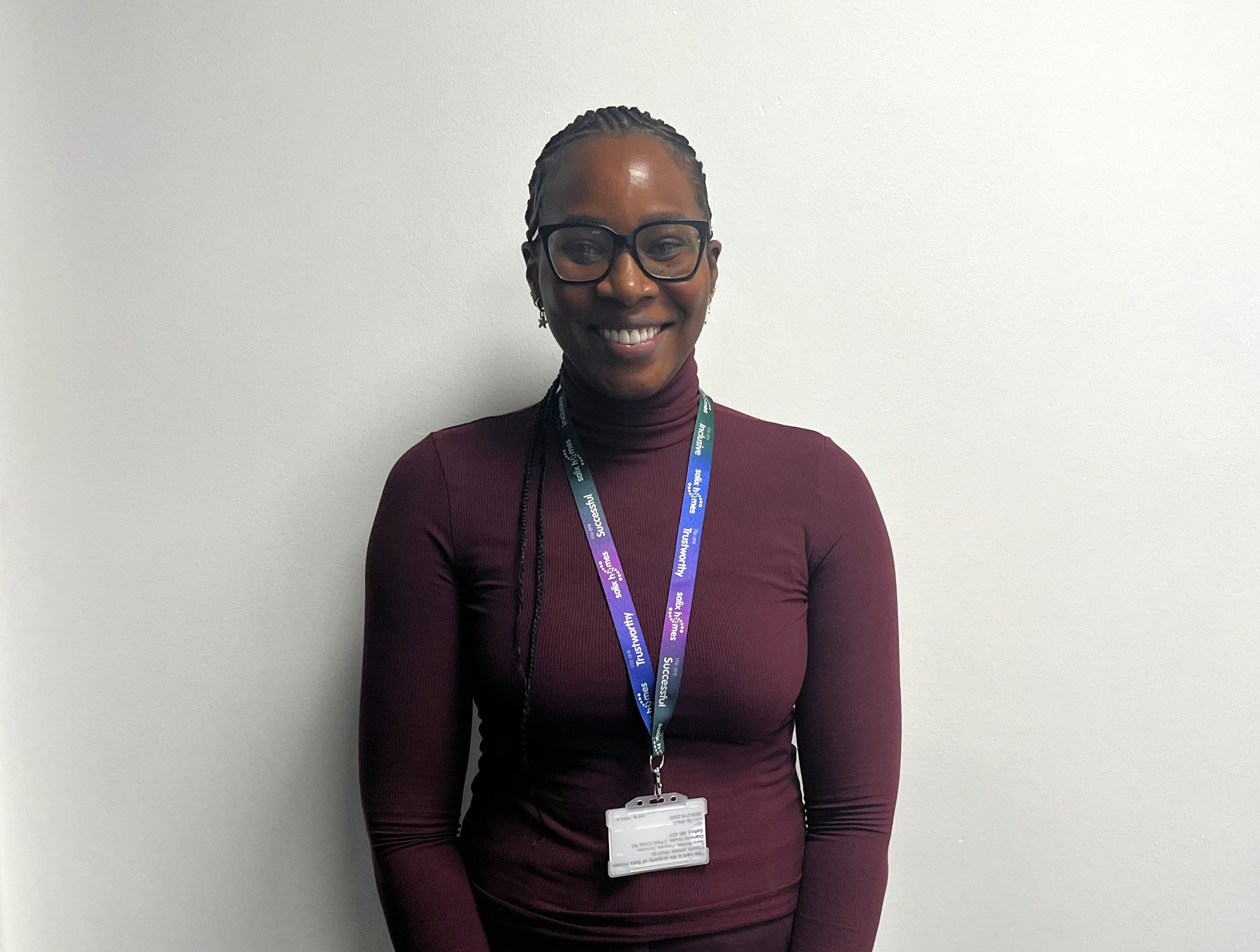 A smiling woman wearing a maroon jumper